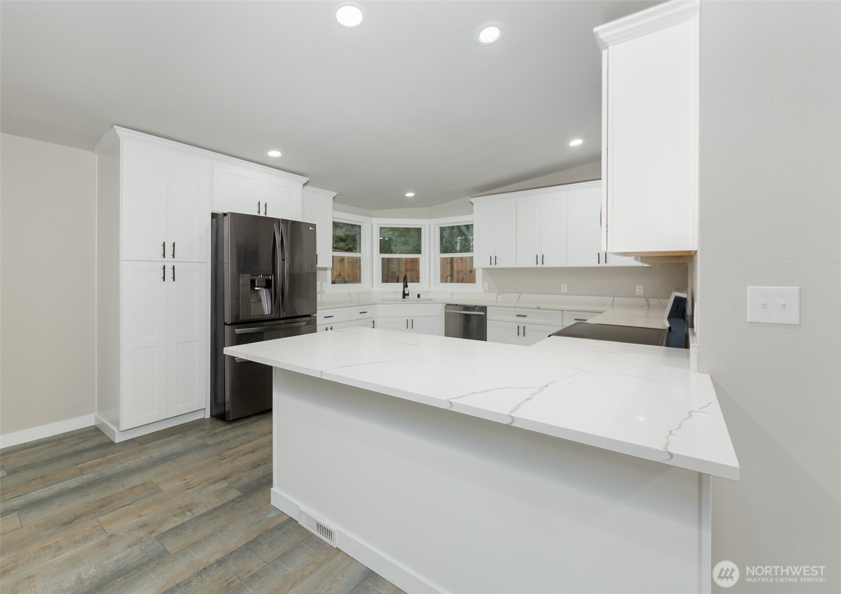 225 North Lake Roesiger Road Snohomish, WA 98290 - Photo 8 of 40 a large white kitchen with kitchen island a sink dishwasher a refrigerator and cabinets