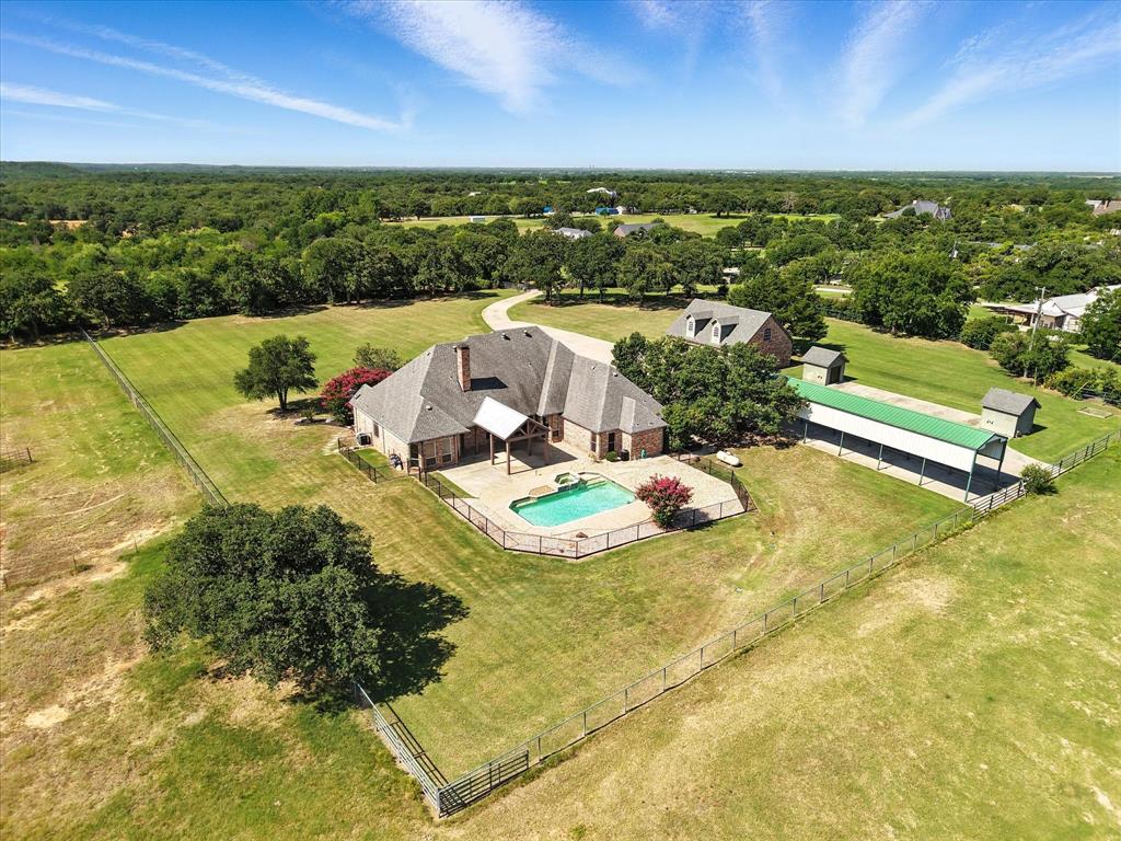 View of subject property with a heavily wooded area and a pool area
