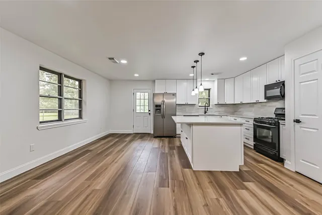 a kitchen with wooden floors and white appliances