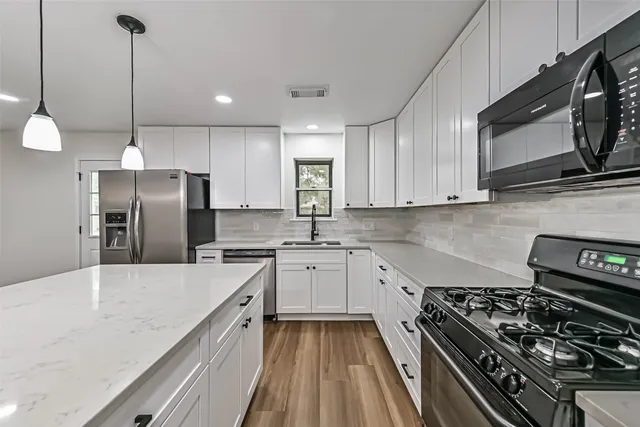 a kitchen with a stove a sink and a refrigerator