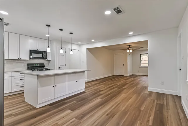 a kitchen with stove cabinets and wooden floor
