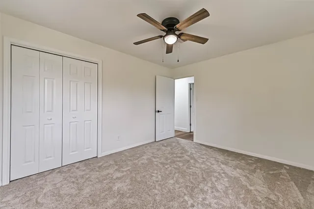 an empty room with a ceiling fan and a fan