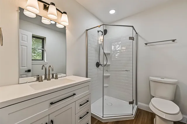 a bathroom with a sink a toilet and shower