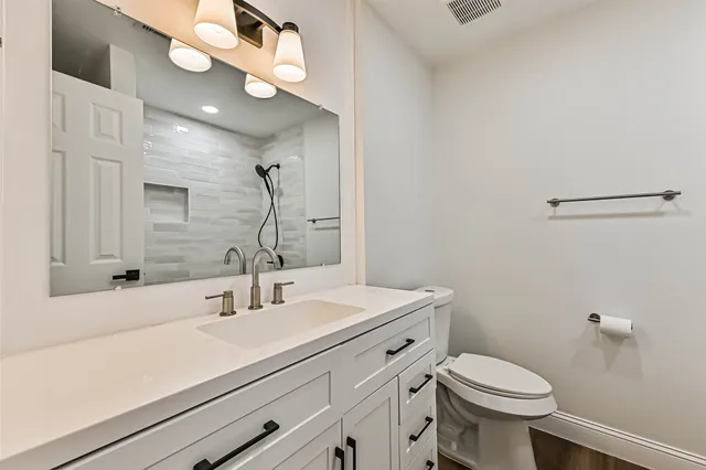 a bathroom with a sink a toilet and a mirror