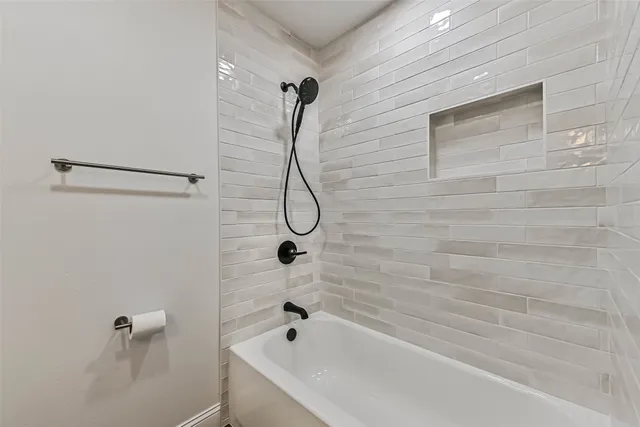 a bathroom with a bath tub with a shower