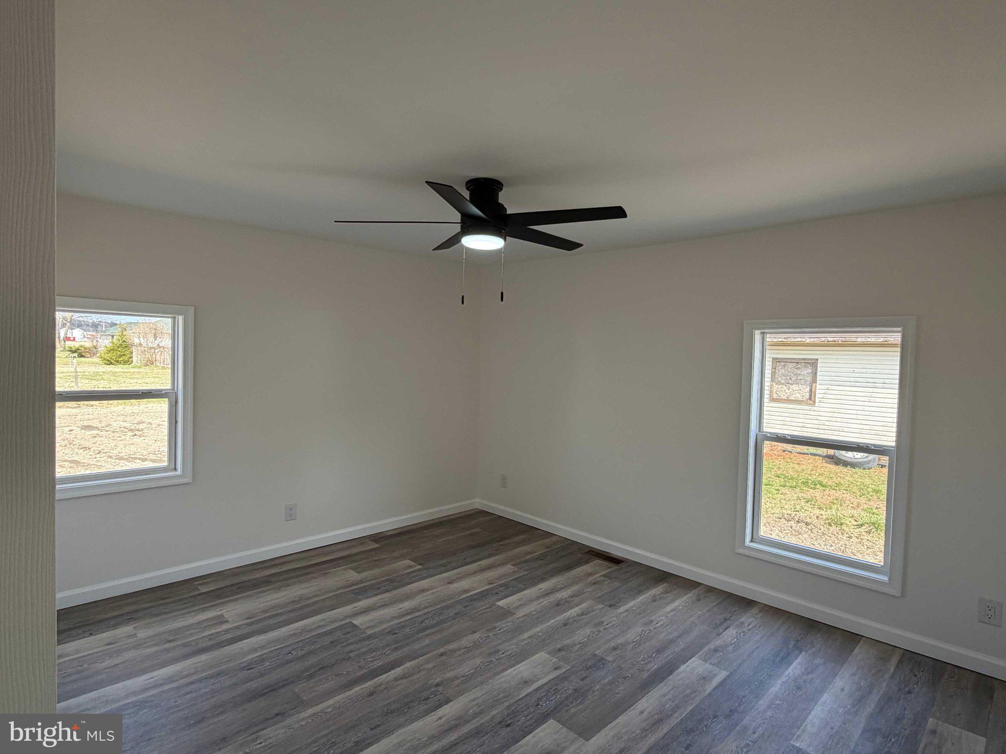 17335 Isdell Road Milford, DE 19963 - Photo 13 of 18 a view of an empty room with wooden floor and a window