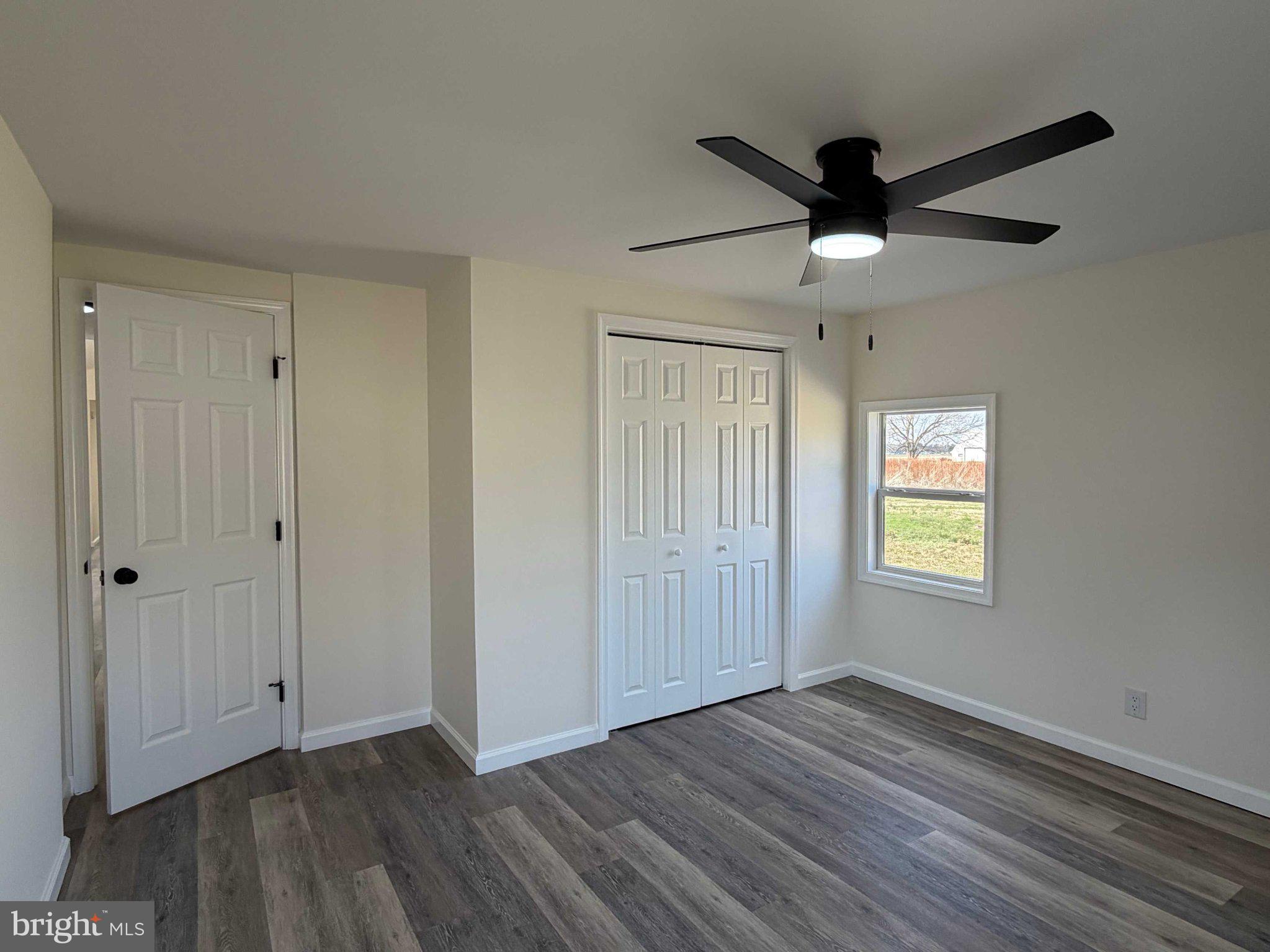 17335 Isdell Road Milford, DE 19963 - Photo 14 of 18 a view of an empty room with a window and wooden floor