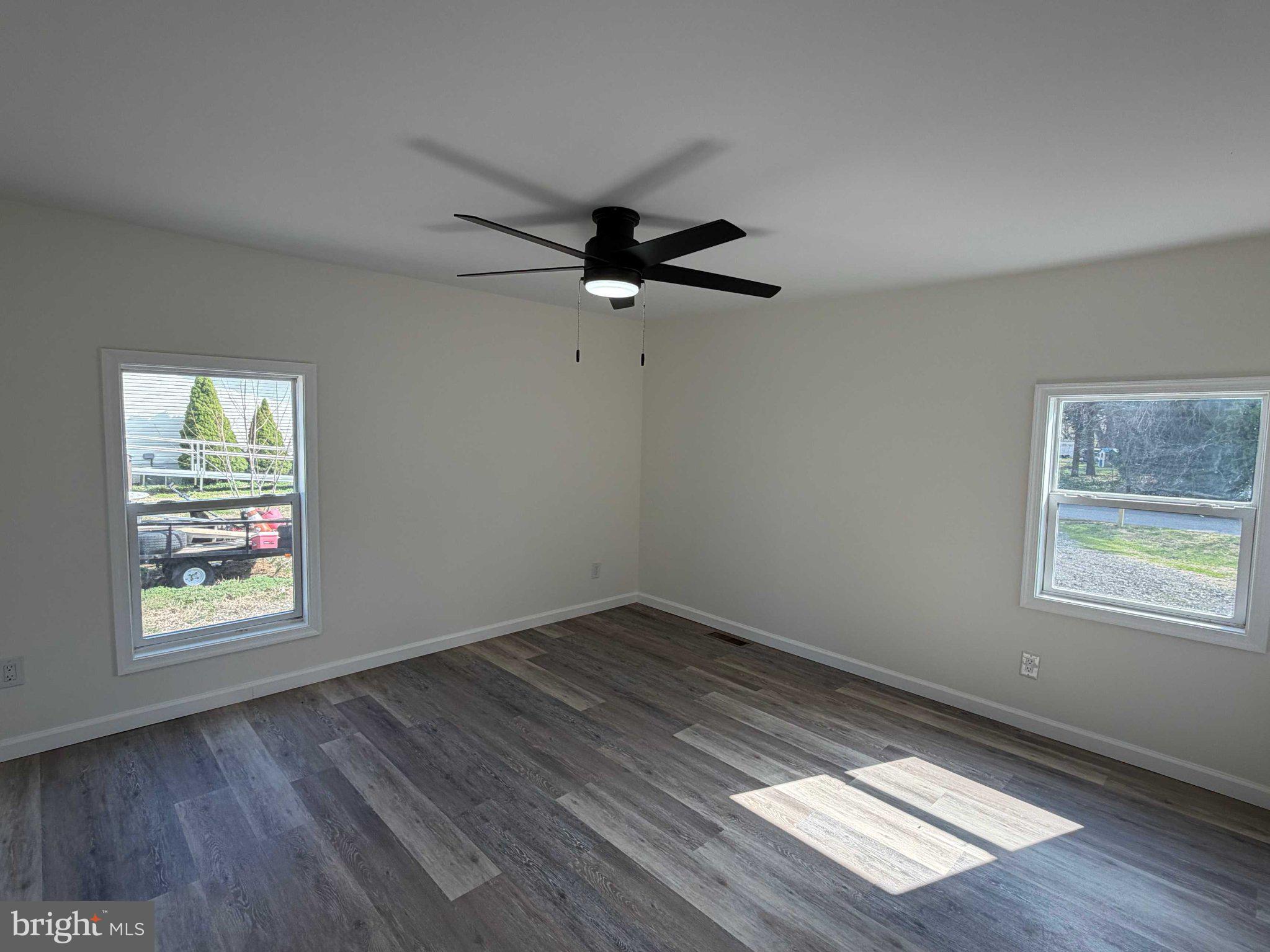 17335 Isdell Road Milford, DE 19963 - Photo 15 of 18 wooden floor in an empty room with a window