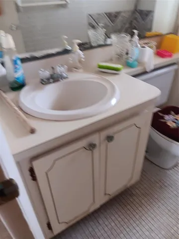 a kitchen with stainless steel appliances granite countertop a sink a refrigerator and white cabinets