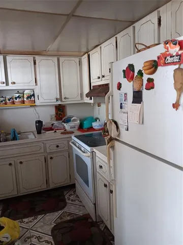 a kitchen with granite countertop a sink a stove and cabinets