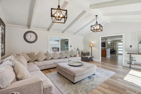 a living room with furniture a clock and a chandelier