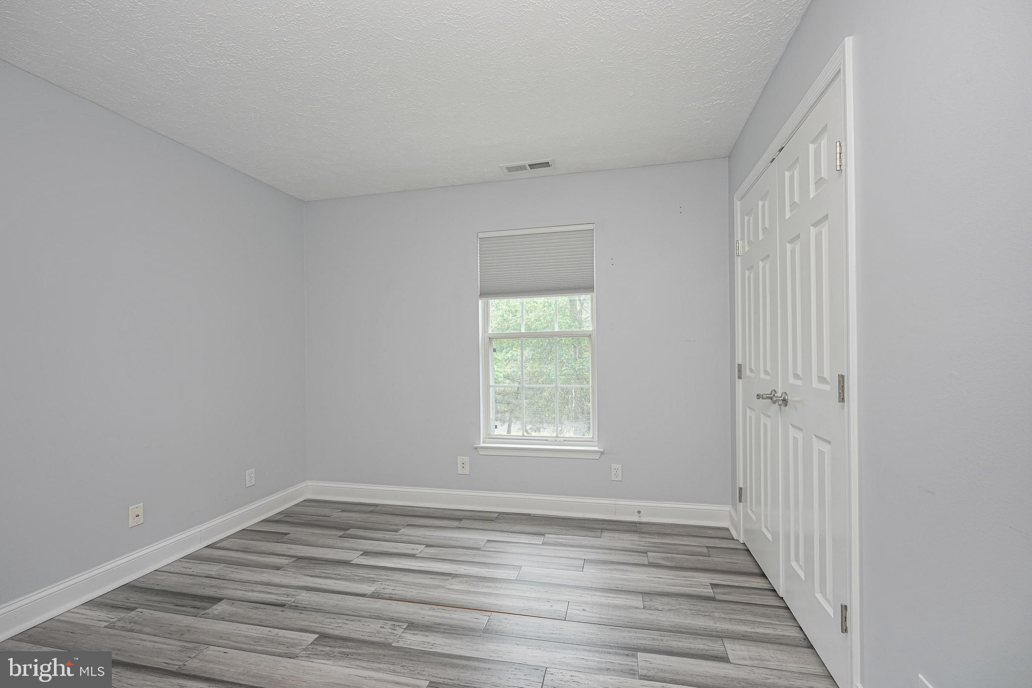 84 Eldon Way Marlton, NJ 08053 - Photo 22 of 27 a view of an empty room with wooden floor and a window