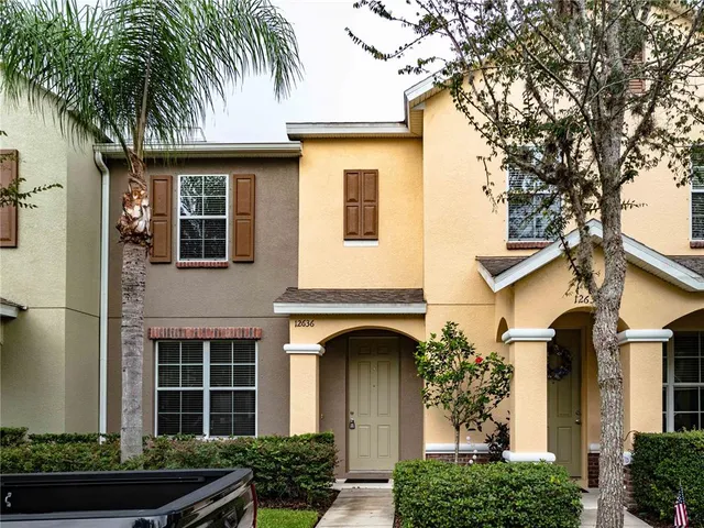 a front view of a house with plants and entryway