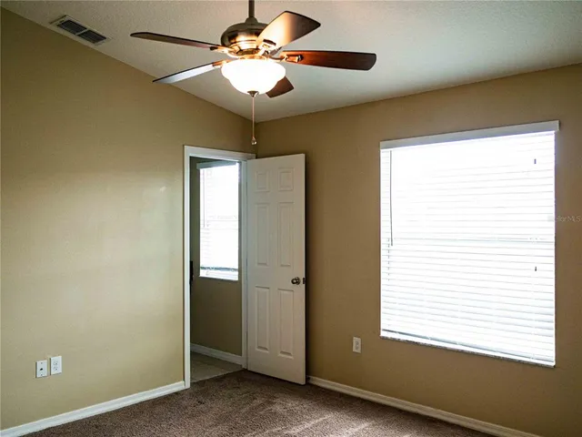 a view of a livingroom with a chandelier fan and a window