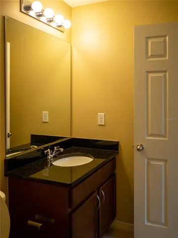an empty room with a flat screen tv and chandelier fan