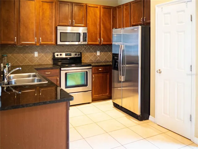 a kitchen with granite countertop a refrigerator and a stove
