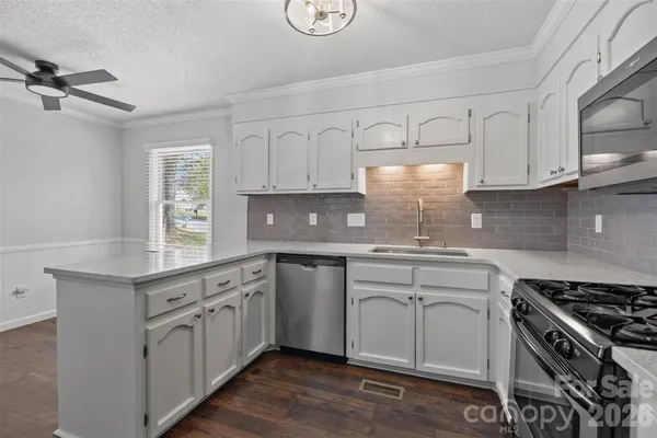 a kitchen with granite countertop white cabinets and white appliances
