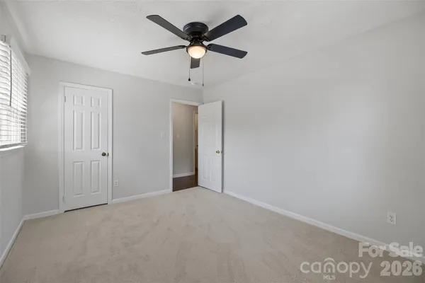 an empty room with a ceiling fan and a window