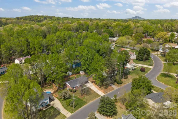 an aerial view of residential houses with outdoor space and trees