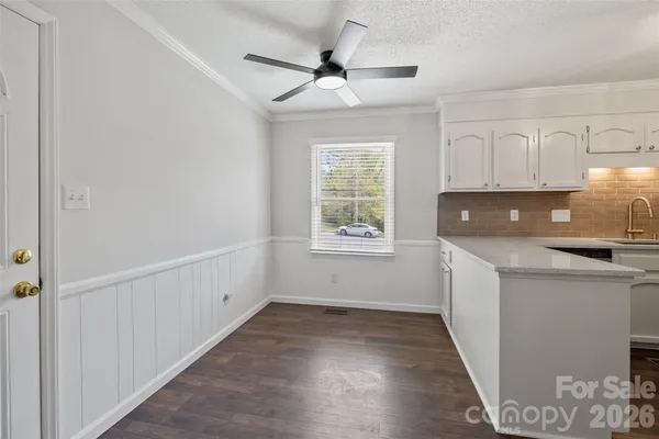 a view of a kitchen with a sink and dishwasher with wooden floor