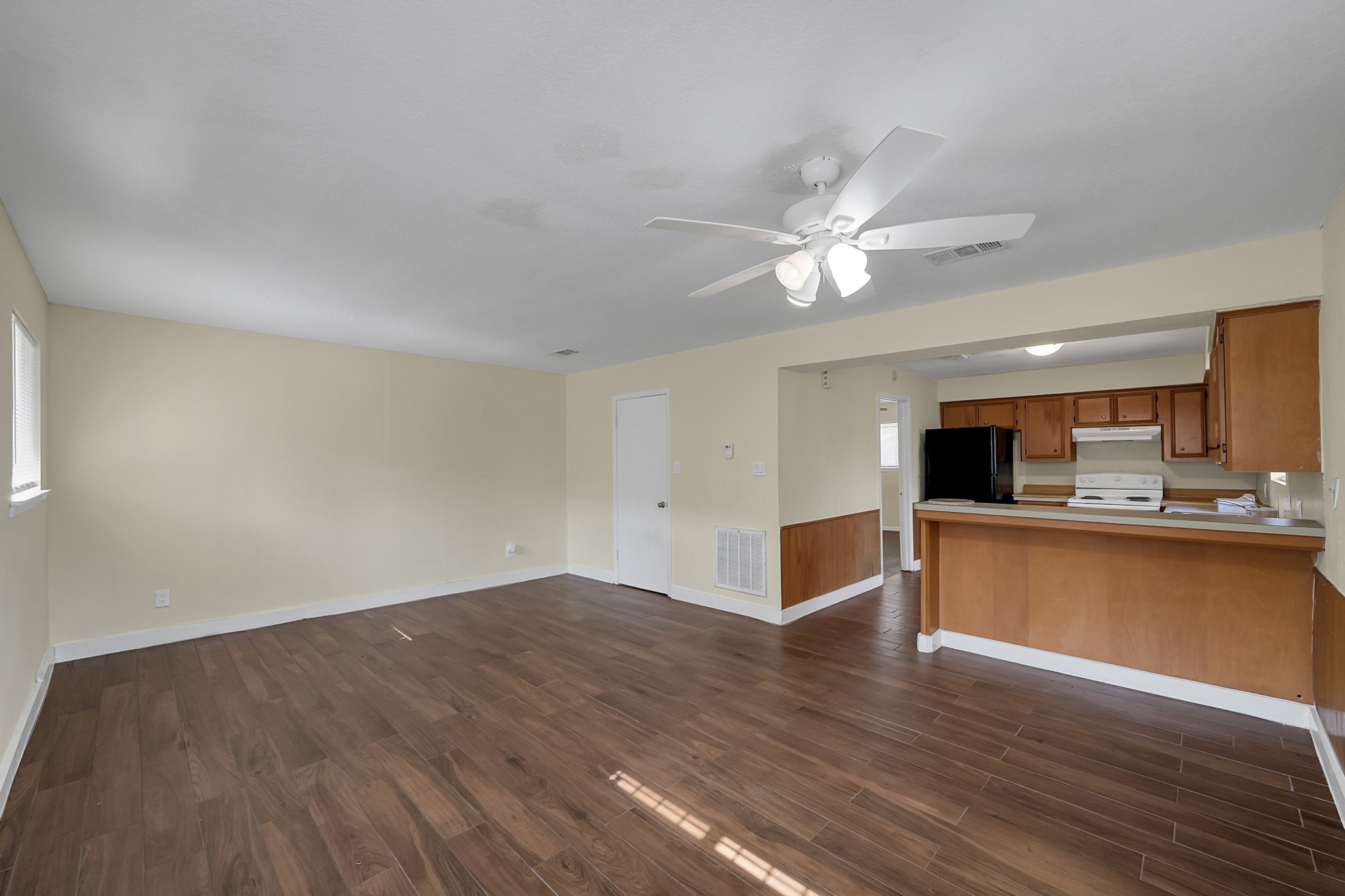 111 Cartwright Road Conroe, TX 77301 - Photo 9 of 19 a view of a kitchen with wooden floor and a ceiling fan