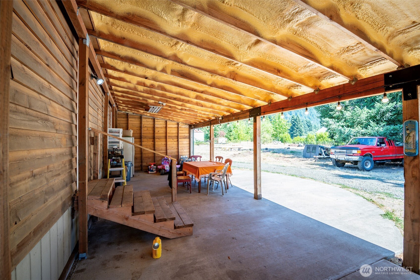142 Gharet Road Randle, WA 98377 - Photo 12 of 32 a view of a patio with a table and chairs under an umbrella with a patio