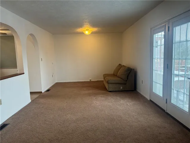 a living room with furniture and a floor to ceiling window