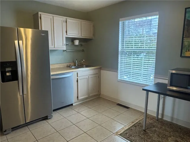 a kitchen with stainless steel appliances a sink cabinets and a window