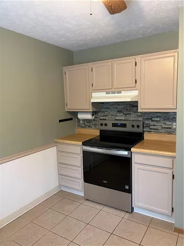 a kitchen with granite countertop white cabinets and white appliances