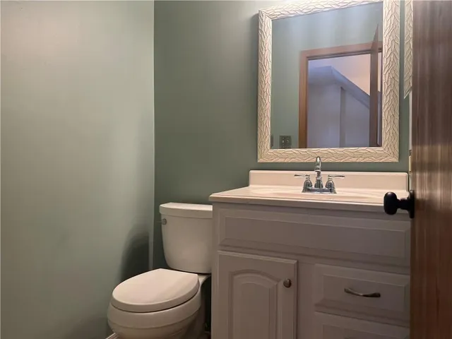 a bathroom with a toilet a sink and mirror