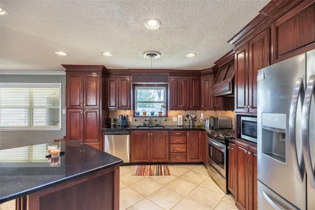a kitchen with granite countertop stainless steel appliances and wooden cabinets