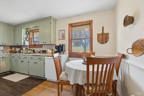 a large kitchen with a table chairs and a wooden floor