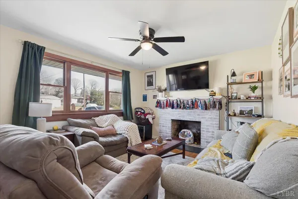 a living room with furniture a flat screen tv and a fireplace