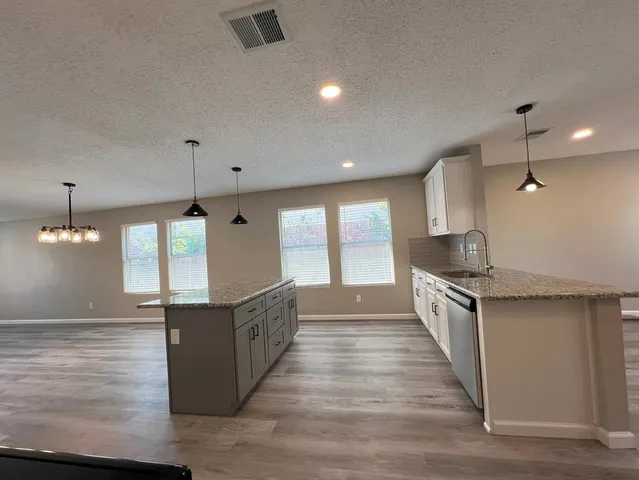 a large kitchen with granite countertop a large counter top space a sink and appliances