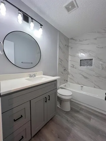 a bathroom with a toilet a sink and mirror