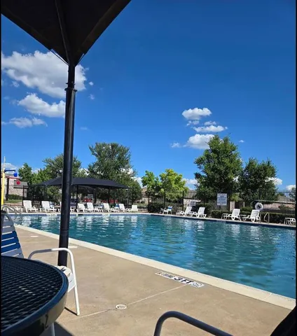 a view of swimming pool with outdoor seating and lake in the background