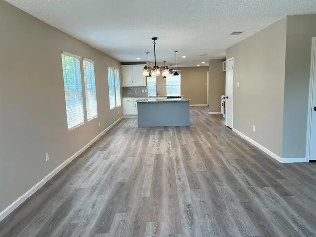 a view of a kitchen with wooden floor and a window
