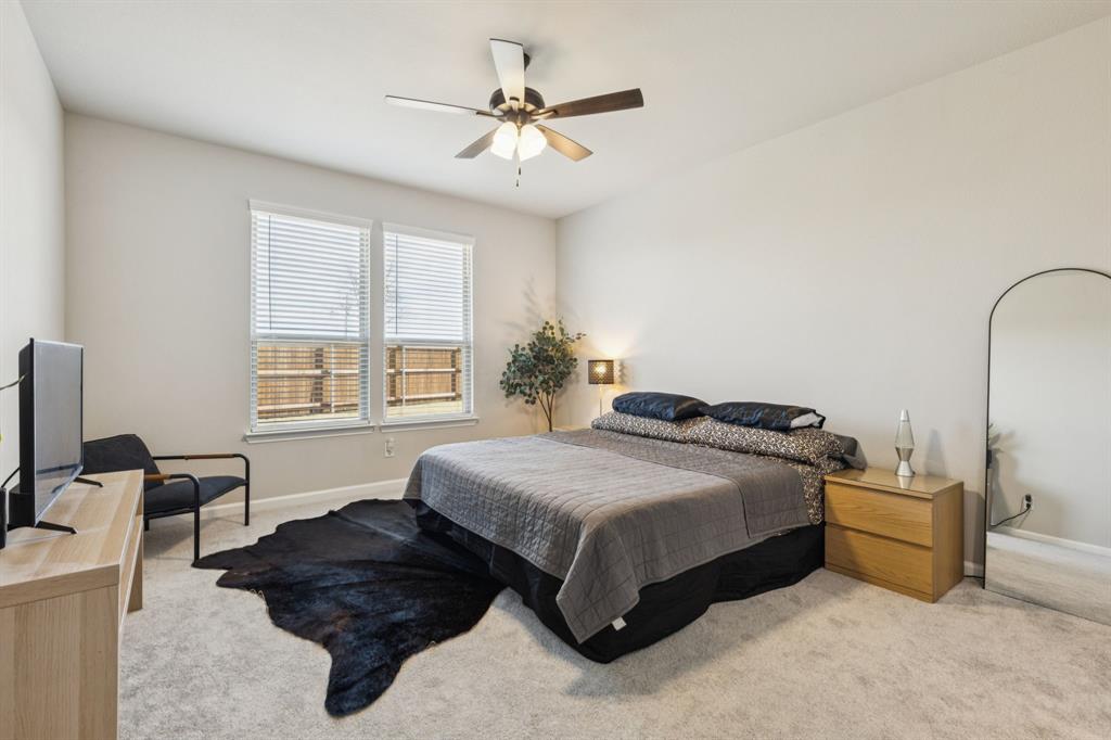 490 Tender Summit Lavon, TX 75166 - Photo 12 of 23 a spacious bedroom with a bed a couch and a chandelier