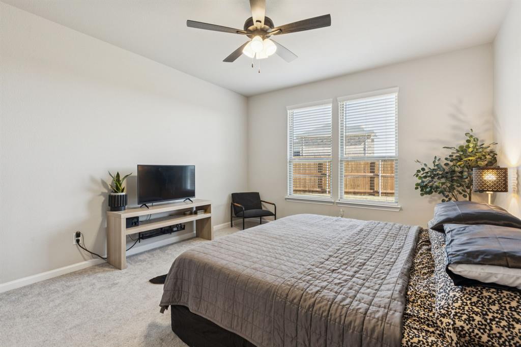 490 Tender Summit Lavon, TX 75166 - Photo 13 of 23 a bedroom with a bed and a flat screen tv