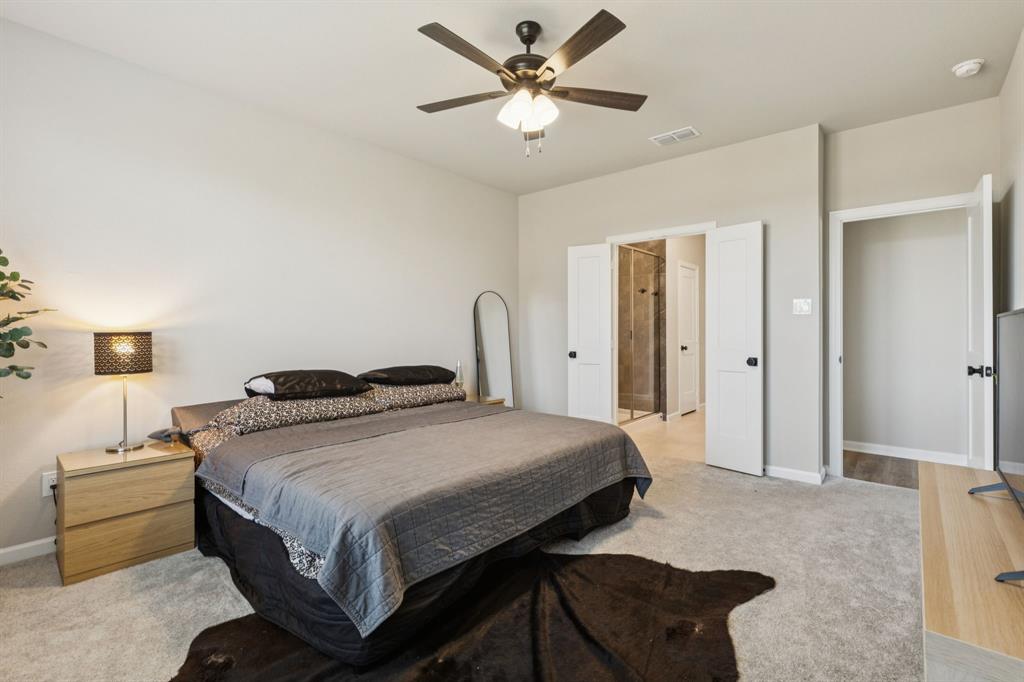 490 Tender Summit Lavon, TX 75166 - Photo 14 of 23 a bedroom with a bed and a chandelier