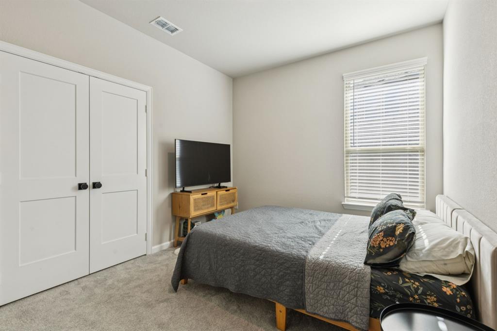 490 Tender Summit Lavon, TX 75166 - Photo 18 of 23 a bedroom with a bed and a flat tv screen
