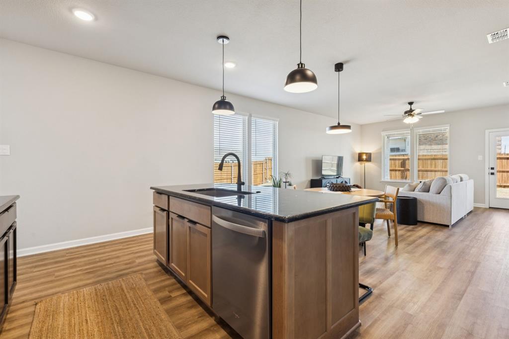490 Tender Summit Lavon, TX 75166 - Photo 6 of 23 a kitchen with stainless steel appliances granite countertop a sink a stove and a wooden floors