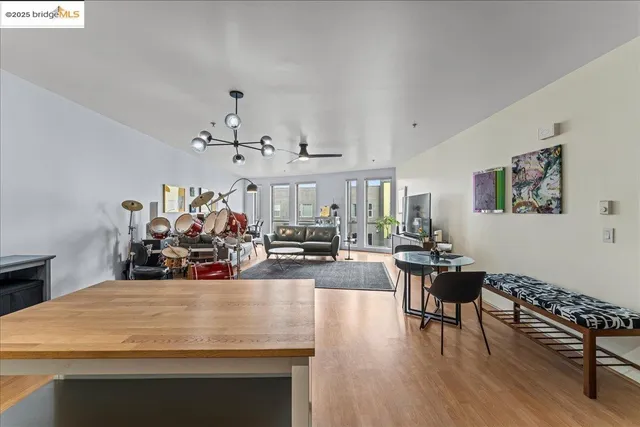a living room with furniture a chandelier and a dining table