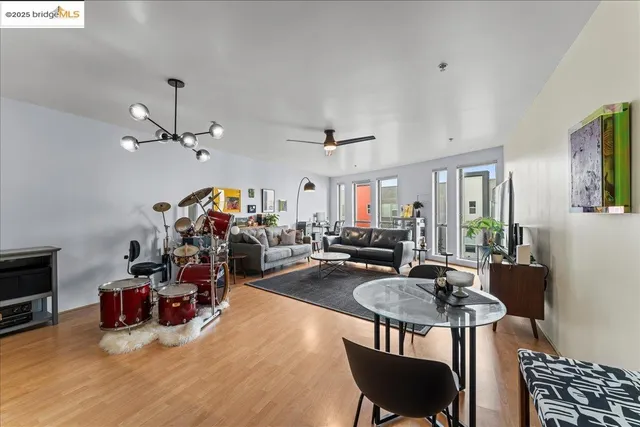 a kitchen with stainless steel appliances granite countertop a stove a refrigerator and a dining table with wooden floors