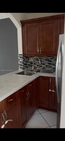 a kitchen with a sink a stove and cabinets