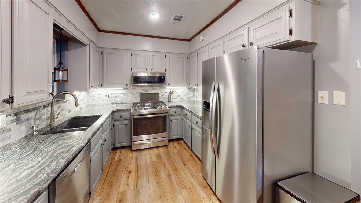 2108 Pantera Drive Bryan, TX 77807 - Photo 8 of 20 a kitchen with stainless steel appliances granite countertop a refrigerator a stove top oven a sink and dishwasher