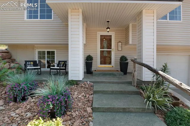 a view of a porch with chairs and potted plants