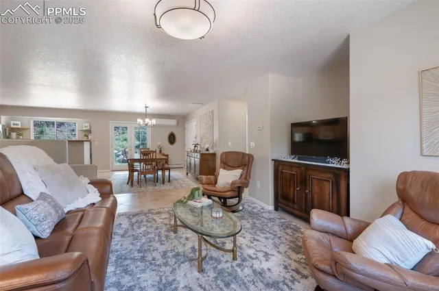 a living room with furniture a flat screen tv and kitchen view