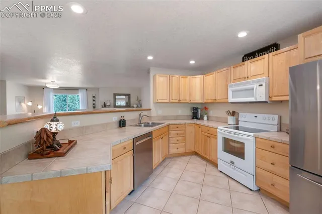 a large kitchen with stainless steel appliances granite countertop a sink and cabinets