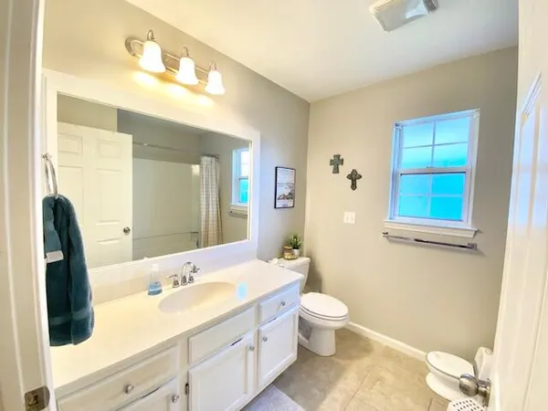 a bathroom with a double vanity sink a toilet and a mirror